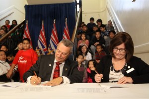 Vancouver School Board chair Patti Bacchus and Minister Fassbender, sign approvals for the $25.6 million upgrading of Lord Strathcona Elementary - which is 122 years old