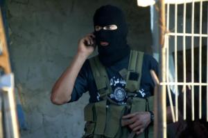 Palestinian terrorist talking on his sold-in-Israel cell phone.