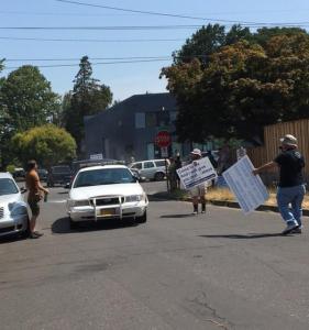 In this photo, you can see the assailant on the left, with the can of Comet still in his hand, as he approached the protestors