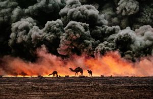 Struggling camels silhouetted against the oil-fire, Al-Ahmadi oil field, Kuwait in 1991. (Credit: Steve McCurry)