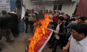 Palestinians burn Angola's flag in a protest amid reports that the country has banned Islam and destroyed mosques. (Credit: APA/Rex)