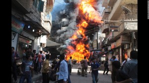 Residents run from a fire at a gasoline and oil shop in Aleppo. (Credit: CNN)